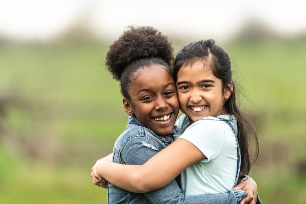 Två barn som kramas och är glada.