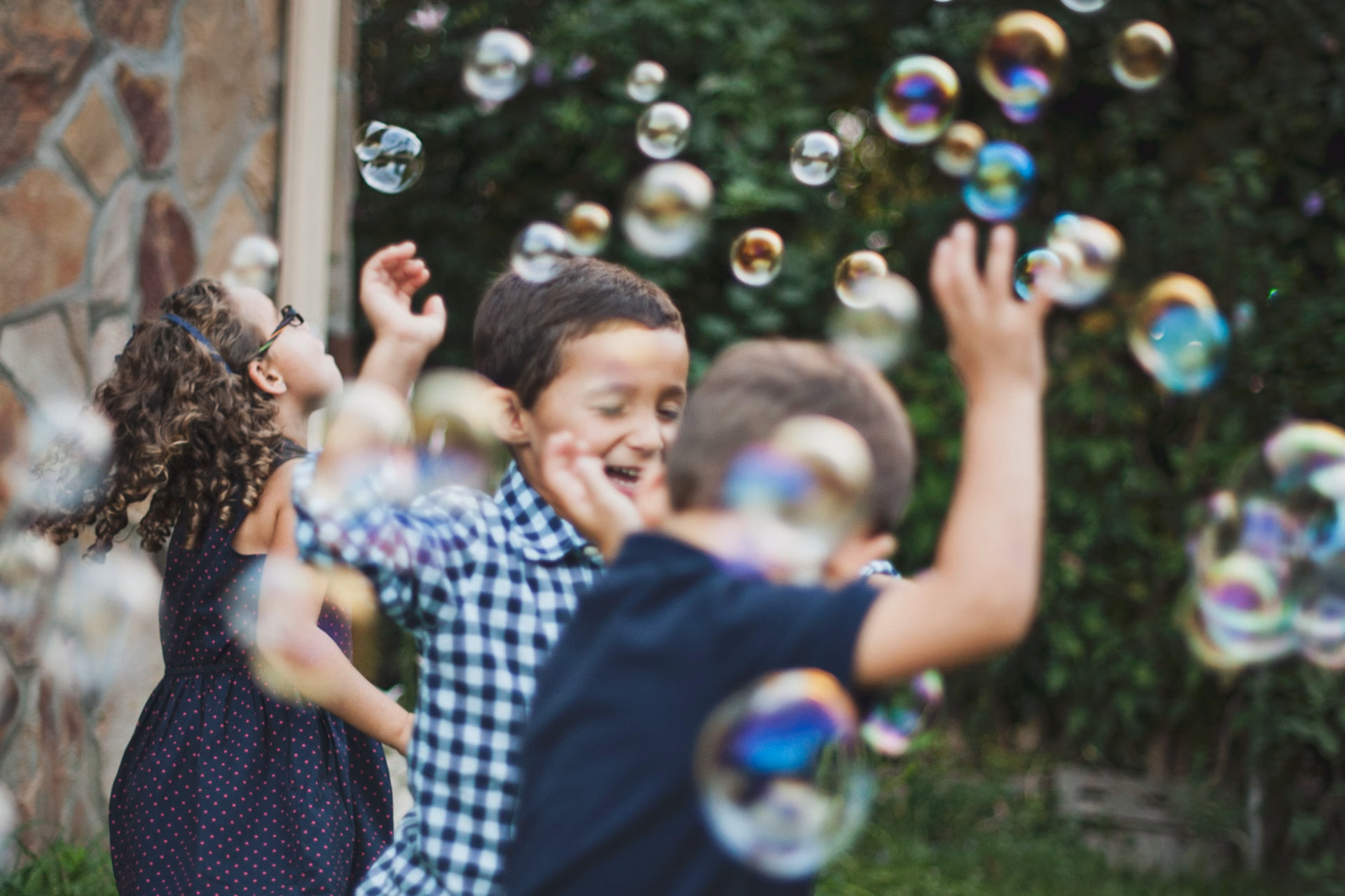 Några barn leker med såpbubblor